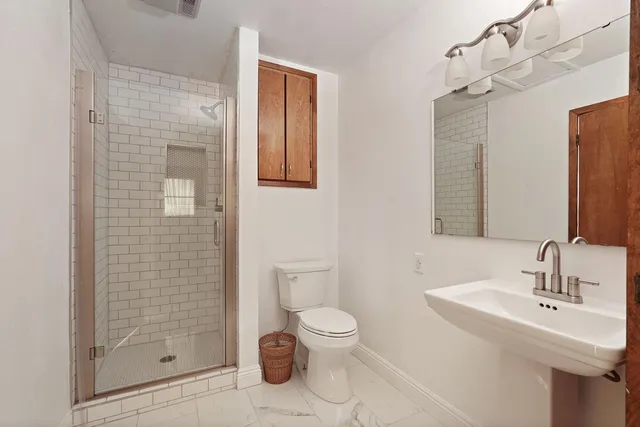 a bathroom with a sink a toilet and shower