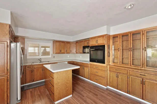 a kitchen with granite countertop a sink stove and refrigerator