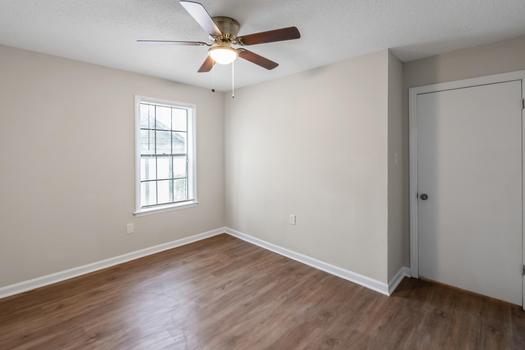 3036 Canyon Road Memphis, TN 38134 - Photo 13 of 24 an empty room with wooden floor ceiling fan and windows