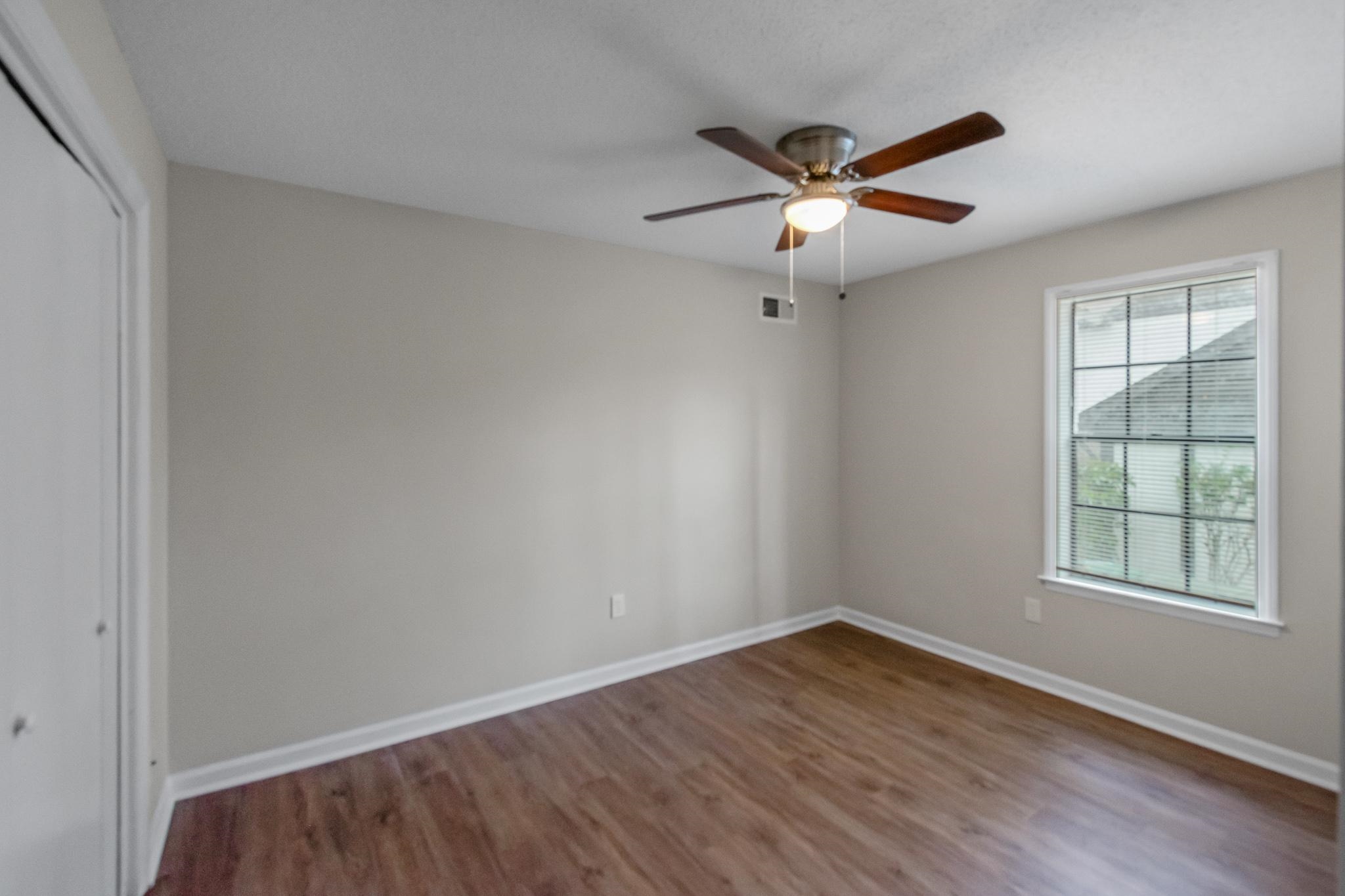 3036 Canyon Road Memphis, TN 38134 - Photo 19 of 24 an empty room with wooden floor ceiling fan and windows