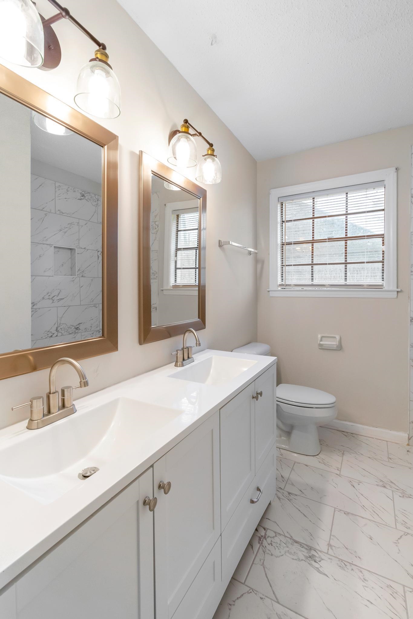 3036 Canyon Road Memphis, TN 38134 - Photo 20 of 24 a bathroom with a double vanity sink toilet and mirror