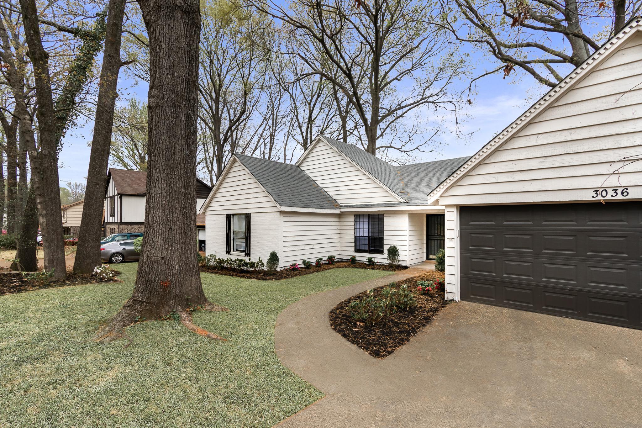 3036 Canyon Road Memphis, TN 38134 - Photo 2 of 24 a front view of a house with a yard and garage