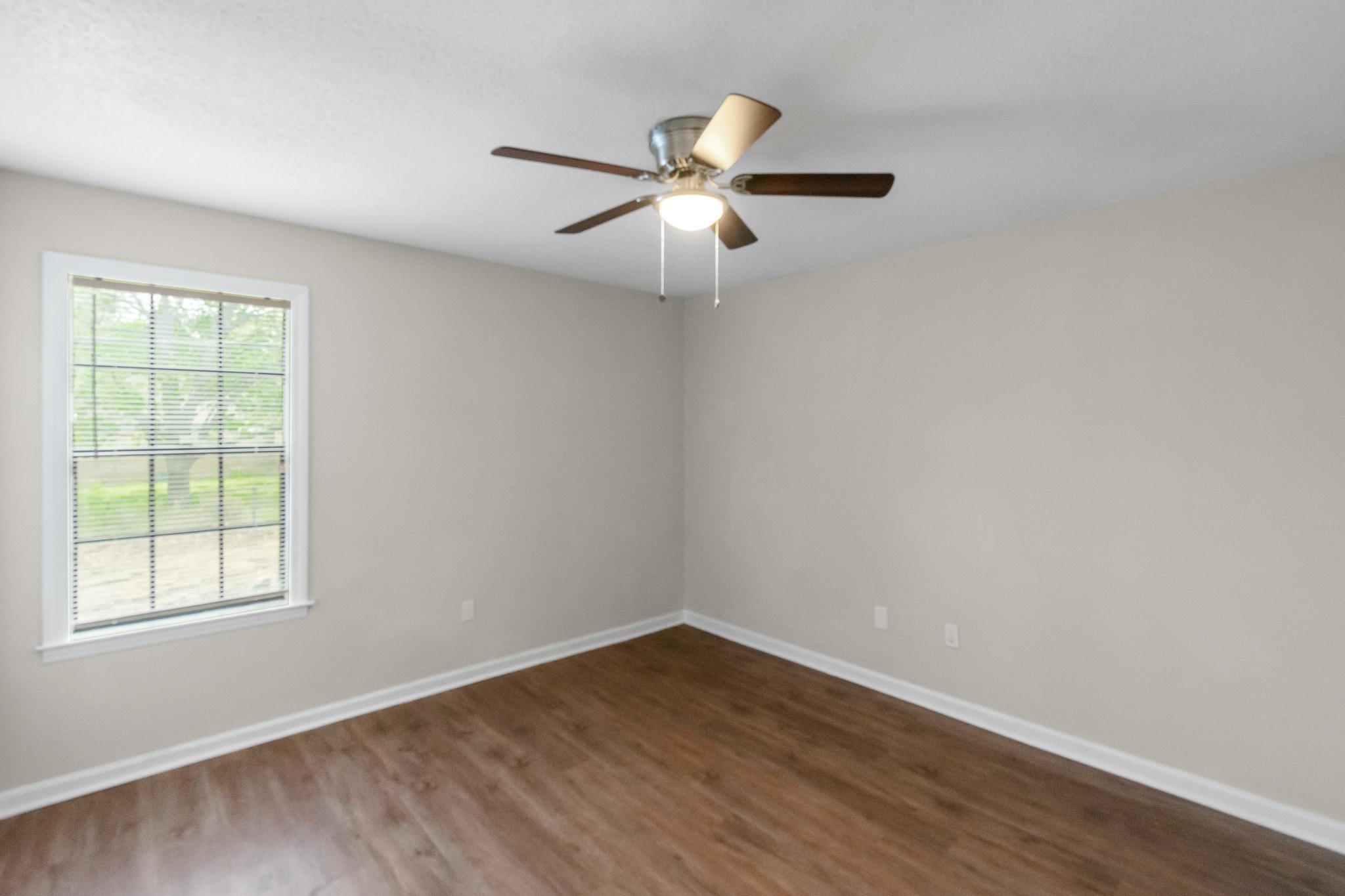 3036 Canyon Road Memphis, TN 38134 - Photo 24 of 24 an empty room with wooden floor fan and windows