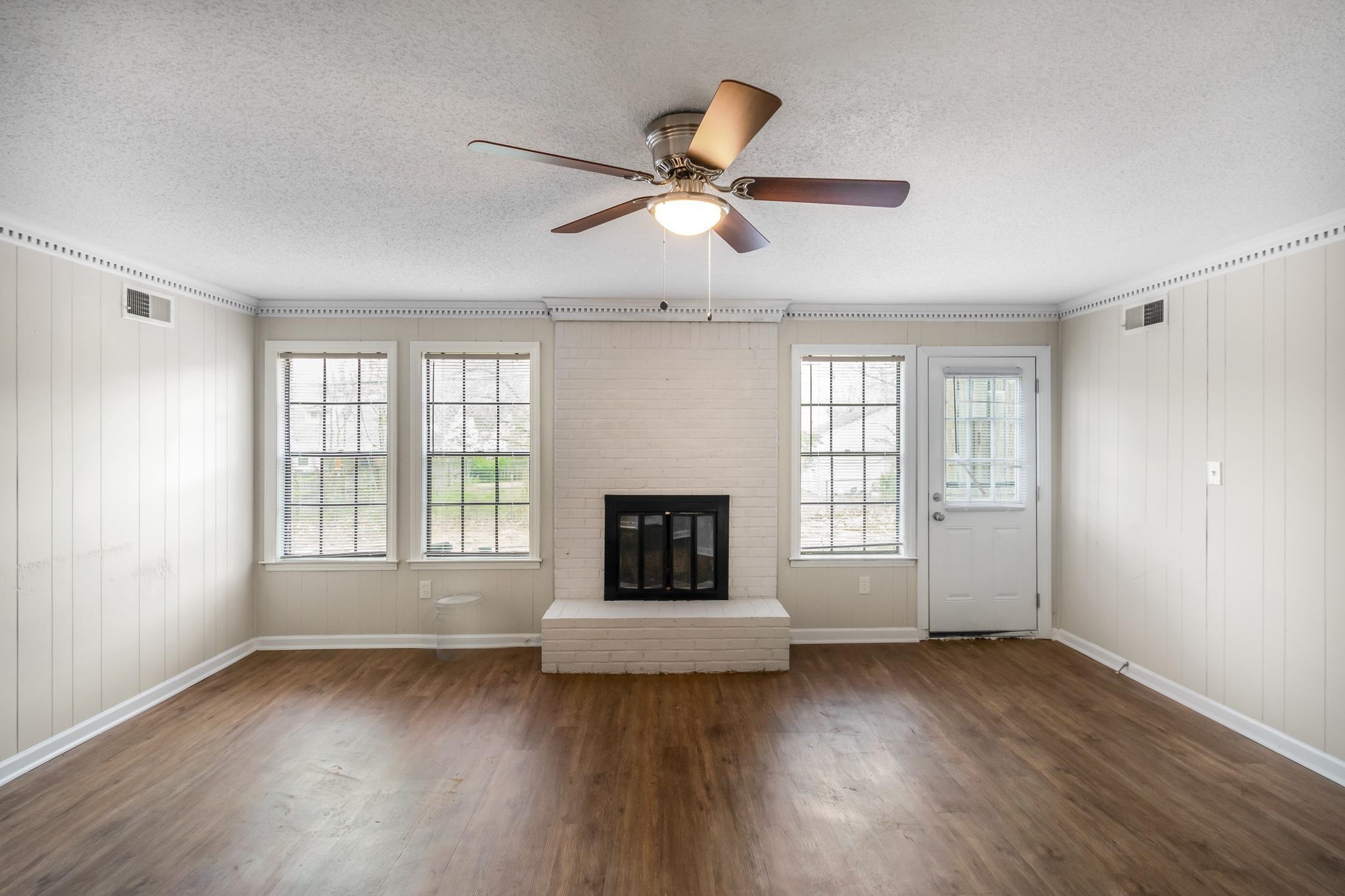 3036 Canyon Road Memphis, TN 38134 - Photo 7 of 24 a living room with a fireplace and wooden floor