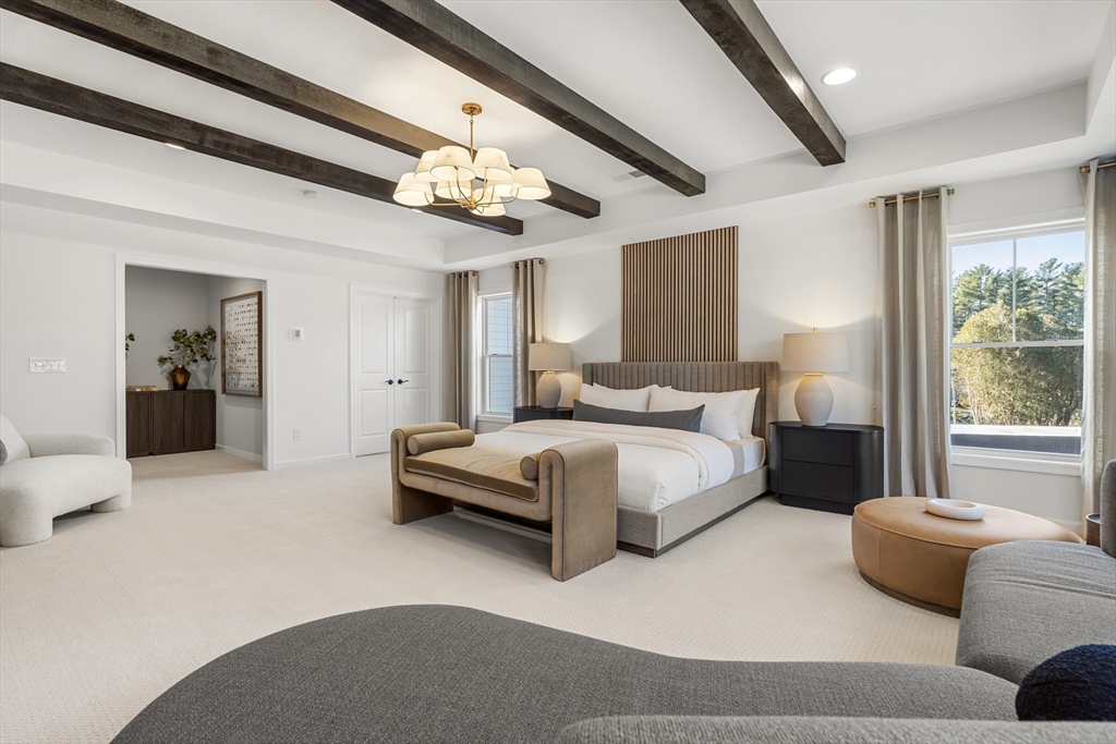 29 Germain Way, Unit 3 Norton, MA 02766 - Photo 33 of 40 a spacious bedroom with a bed couch chandelier and a window