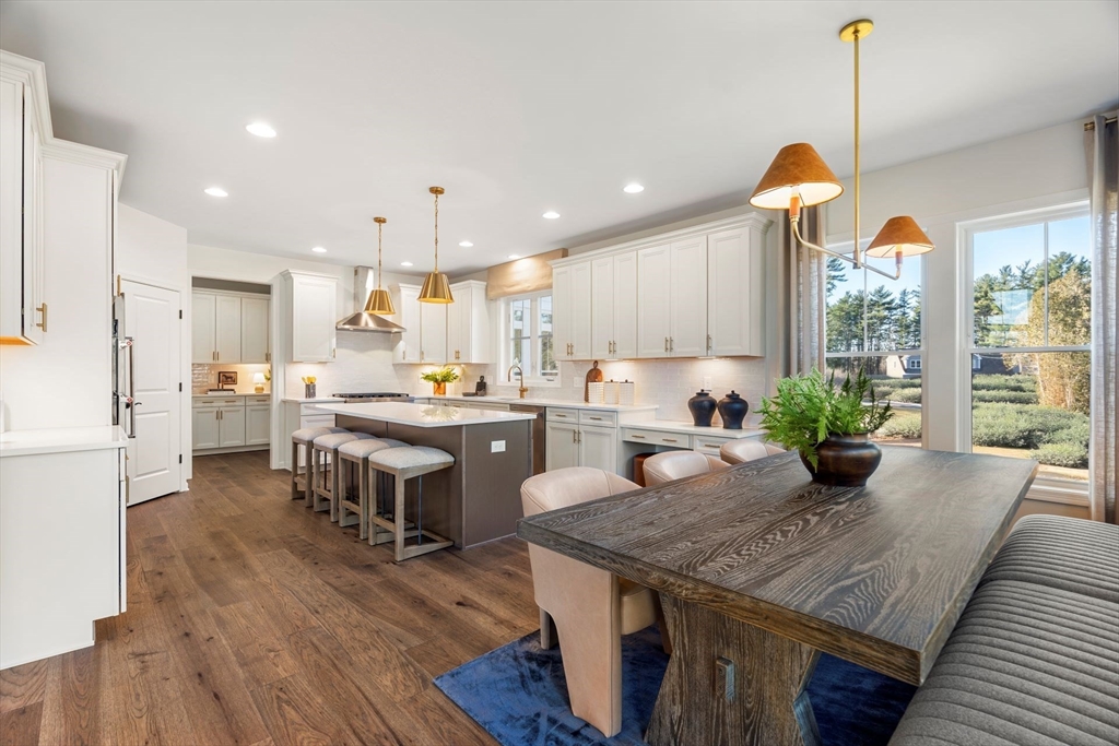 29 Germain Way, Unit 3 Norton, MA 02766 - Photo 9 of 40 a kitchen with a refrigerator a sink and a dining table with wooden floor