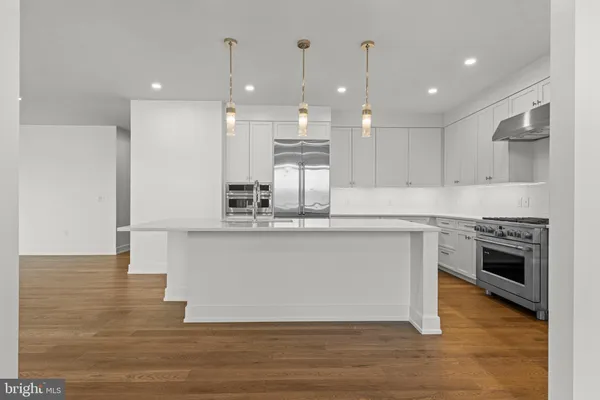 a kitchen with kitchen island a counter top space a stove and cabinets