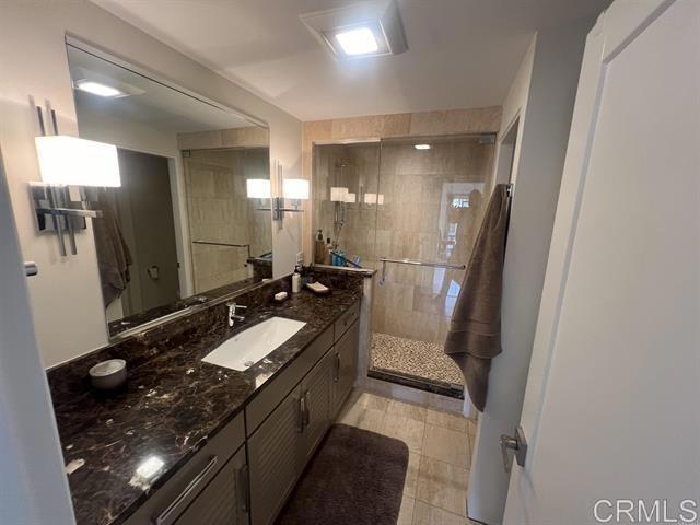 7061 Estrella De Mar Road, Unit 66 Carlsbad, CA 92009 - Photo 13 of 17 a bathroom with a double vanity sink a toilet a mirror and a shower