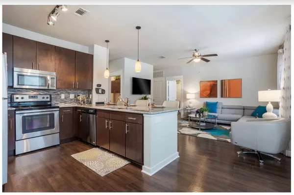 a kitchen with stainless steel appliances kitchen island granite countertop a stove and a sink
