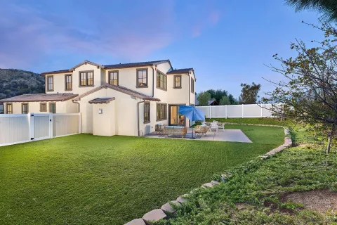 a view of an house with swimming pool lawn chairs and a yard