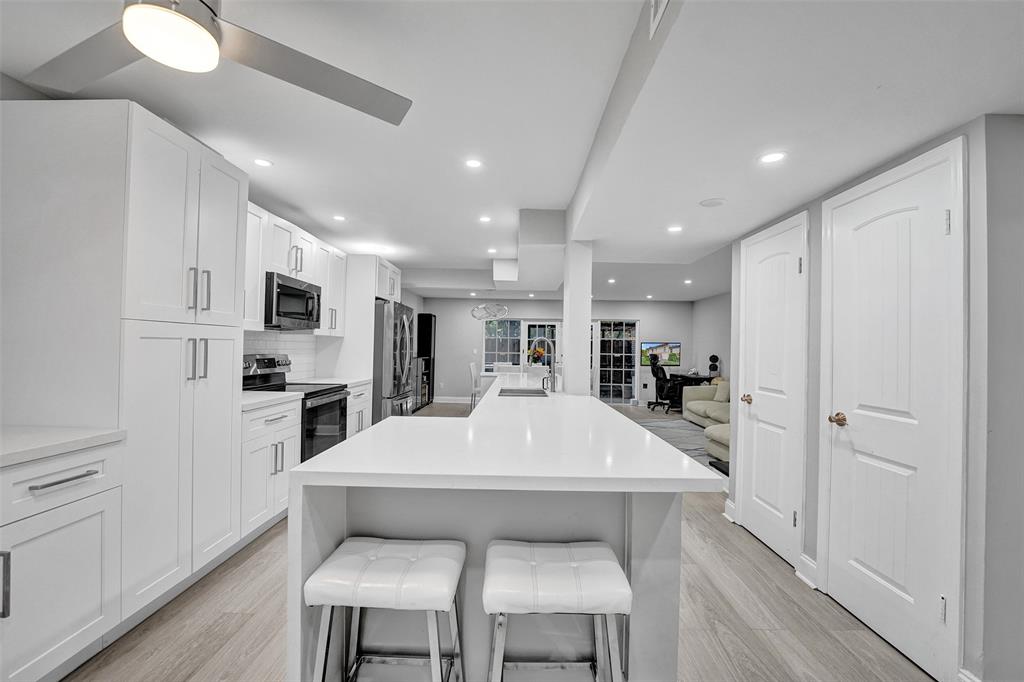 3301 Raleigh Street, Unit 4B Hollywood, FL 33021 - Photo 7 of 54 a large white kitchen with white cabinets and stainless steel appliances