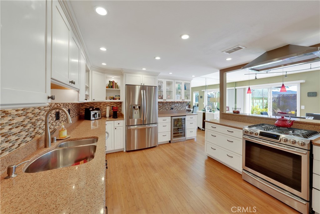 2422 Miseno Way Costa Mesa, CA 92627 - Photo 10 of 40 a kitchen with stainless steel appliances kitchen island granite countertop a stove and a sink