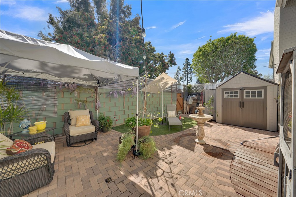 2422 Miseno Way Costa Mesa, CA 92627 - Photo 14 of 40 a view of a patio with a table and chairs under an umbrella with a fire pit