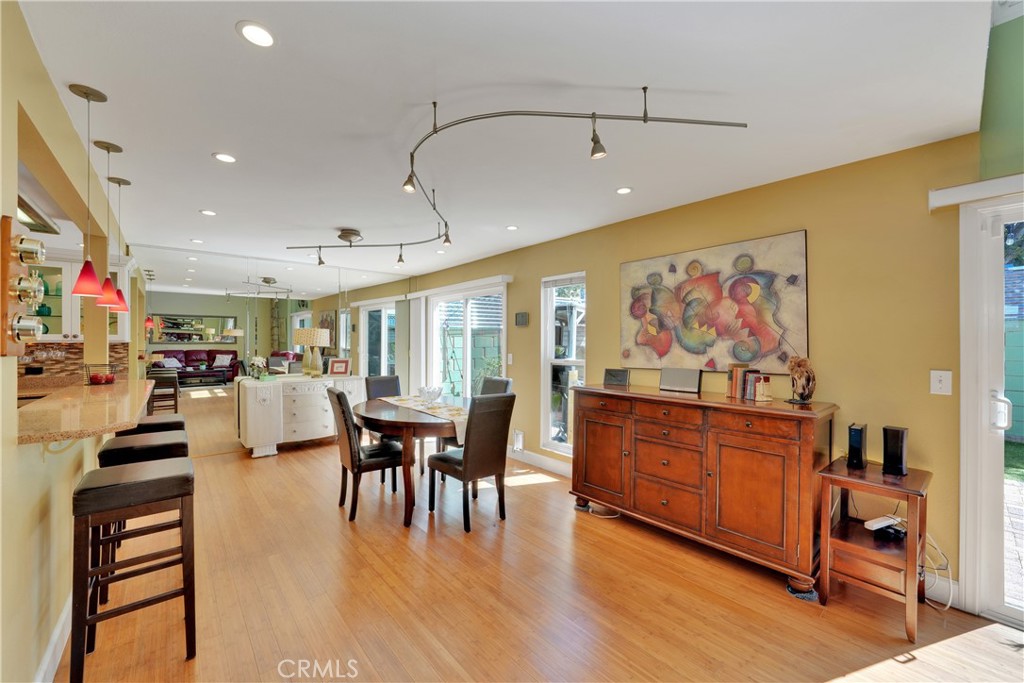 2422 Miseno Way Costa Mesa, CA 92627 - Photo 19 of 40 a dining hall with stainless steel appliances granite countertop a stove a refrigerator a dining table and chairs with wooden floor