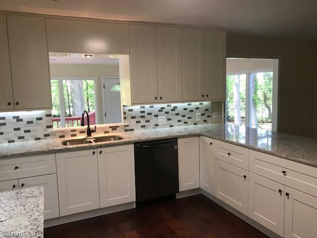 2824 Montclair Road Winston-Salem, NC 27106 - Photo 4 of 30 Kitchen features granite countertops, new cabinets, tile backsplash, new black SS appliances, under cabinet lighting, and hardwood flooring!