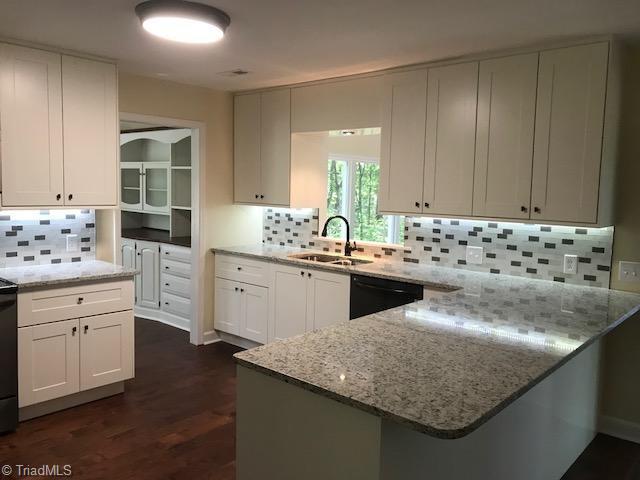 2824 Montclair Road Winston-Salem, NC 27106 - Photo 5 of 30 Kitchen features granite countertops, new cabinets, under cabinet lighting tile backsplash, new black SS appliances, and hardwood flooring!