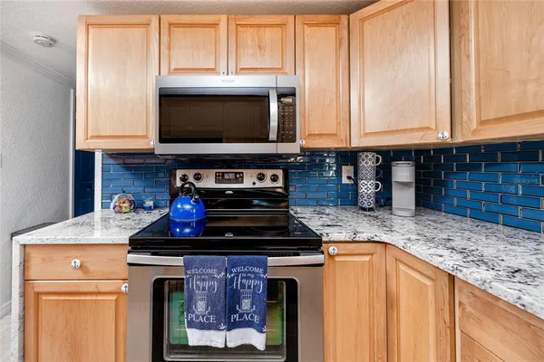 a kitchen with granite countertop a stove and a sink
