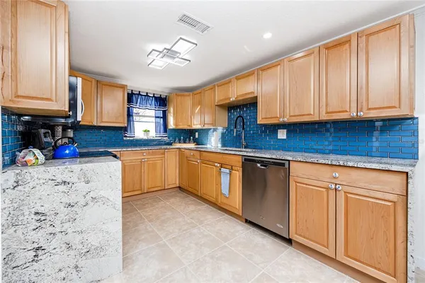 a kitchen with stainless steel appliances granite countertop a sink a stove cabinets counter space and a window