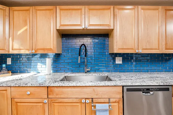 a kitchen with granite countertop wooden cabinets a sink and a window