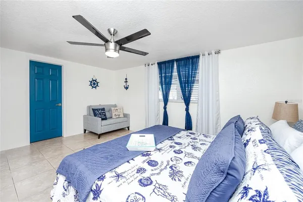 a bedroom with a large bed and a chandelier