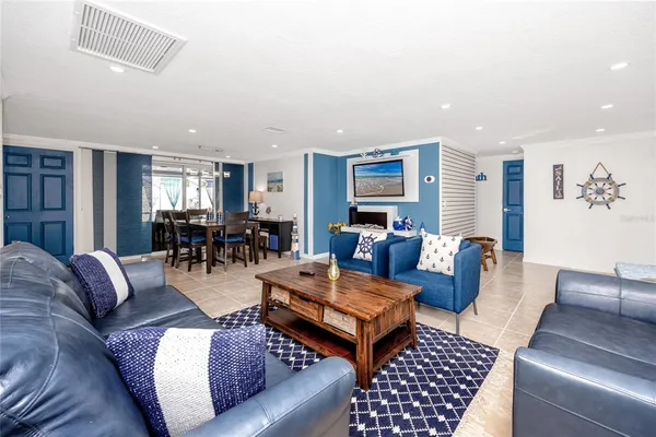 a living room with furniture kitchen view and a large window