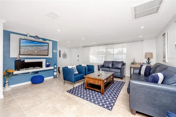 a living room with furniture flat screen tv and couches