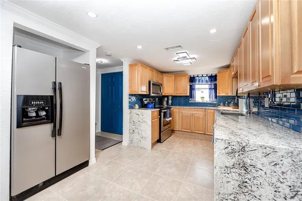 a kitchen with stainless steel appliances granite countertop a refrigerator and a stove top oven