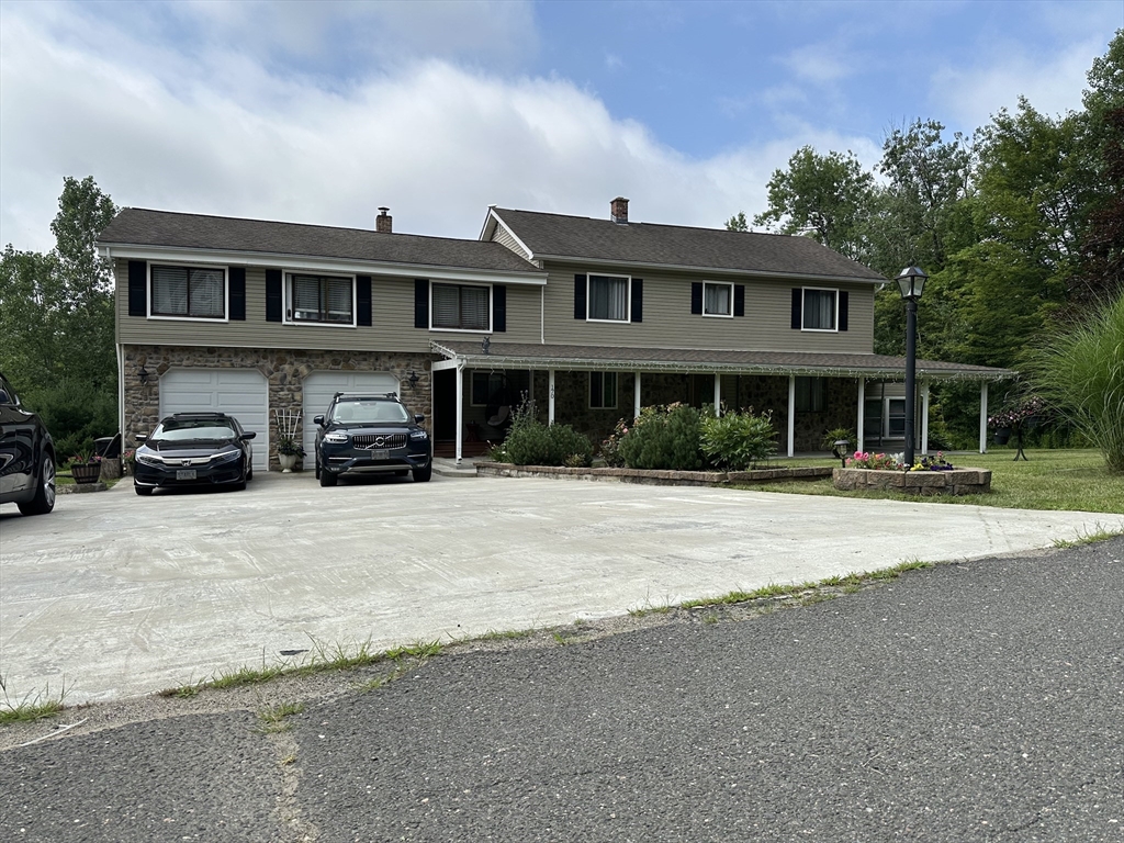 a front view of a house with cars parked