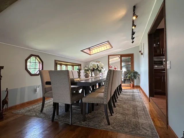 a dining room with furniture a rug and wooden floor