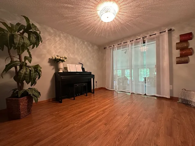 a view of a room with wooden floor and a chandelier