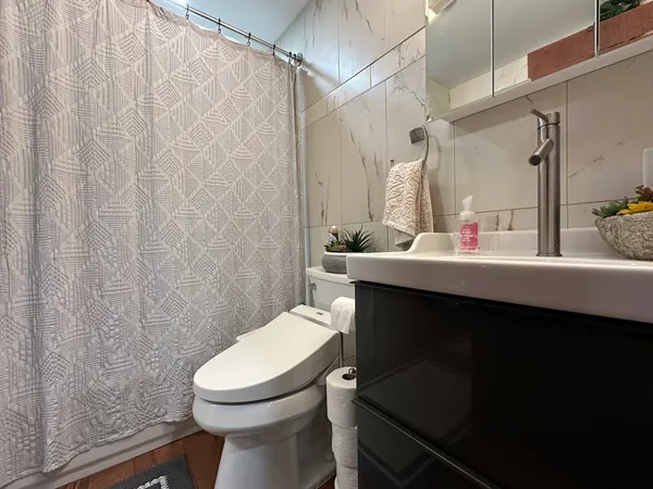 a bathroom with a sink vanity mirror and toilet