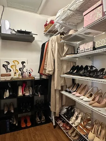 a view of walk in closet with clothes and shoes