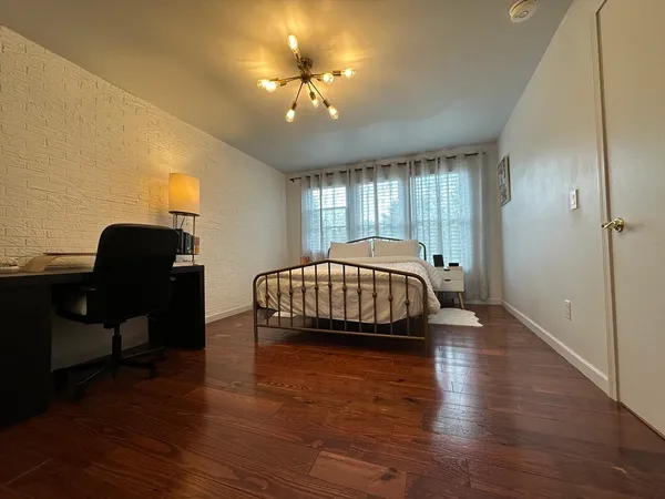 a bedroom with a bed windows and a chandelier