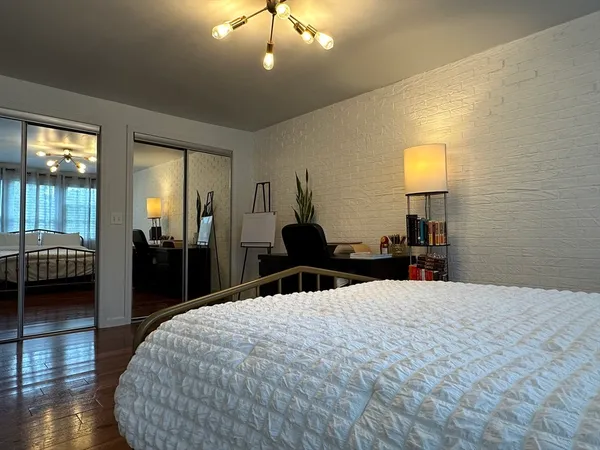 a large bedroom with a bed and wooden floor