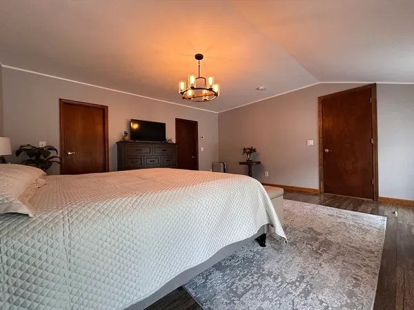 a bedroom with a bed and a chandelier