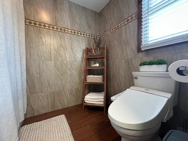 a bathroom with a toilet and a shower curtain