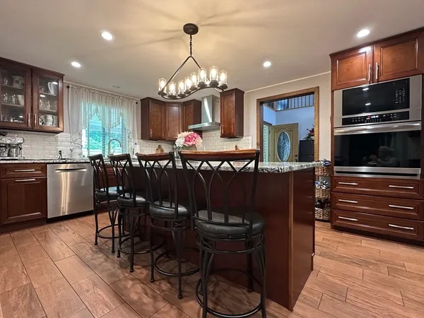 a view of a dining room with furniture a chandelier and wooden floor