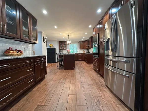 a kitchen with stainless steel appliances granite countertop a refrigerator and a stove top oven