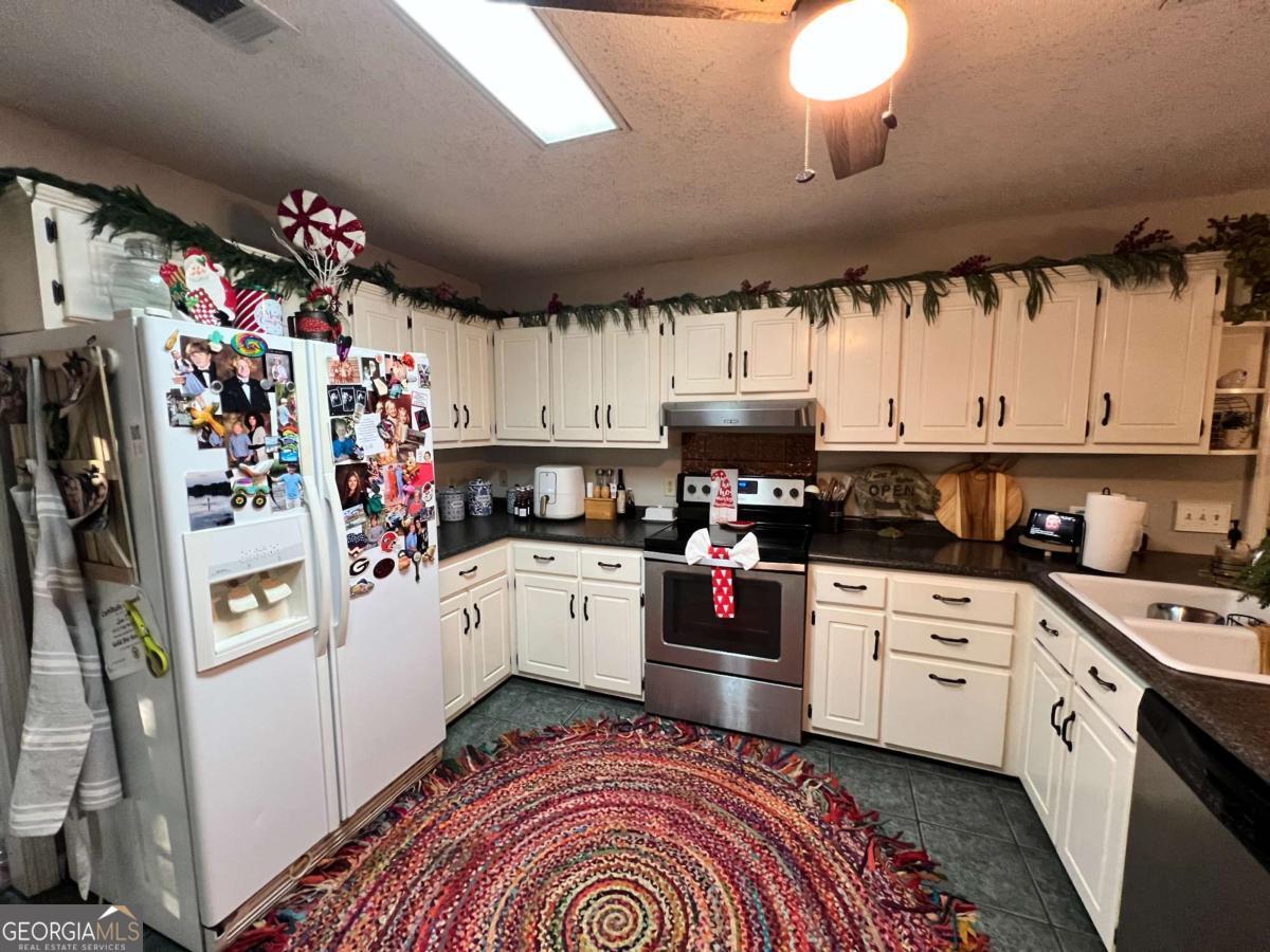 2003 Chevy Place Vidalia, GA 30474 - Photo 5 of 26 a kitchen with granite countertop a white stove top oven and cabinets
