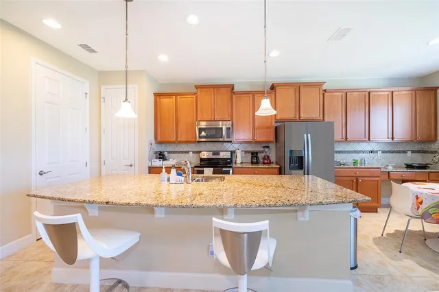 a kitchen with stainless steel appliances granite countertop a sink a stove and a refrigerator