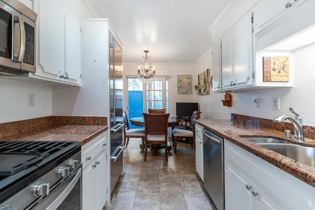 a kitchen with granite countertop stainless steel appliances a sink and cabinets