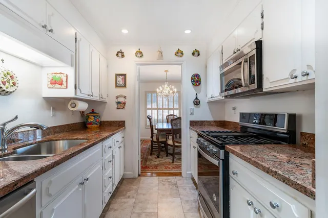 a kitchen with granite countertop stainless steel appliances sink and cabinets