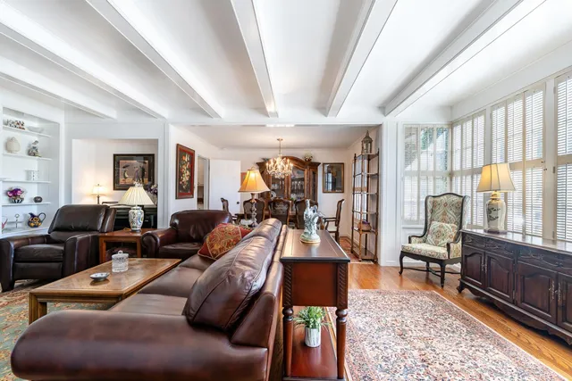 a living room with furniture fireplace and a large window