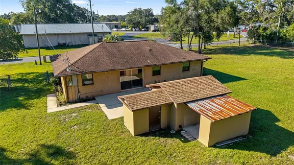 a aerial view of a house with swimming pool lawn chairs and a yard