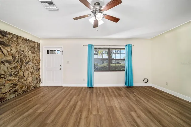 a view of a livingroom with wooden floor and a ceiling fan
