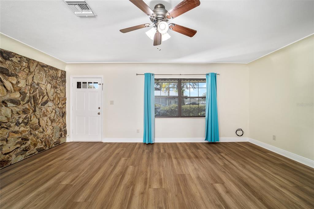 5201 East Jasmine Lane Inverness, FL 34453 - Photo 20 of 50 a view of a room with wooden floor and a ceiling fan