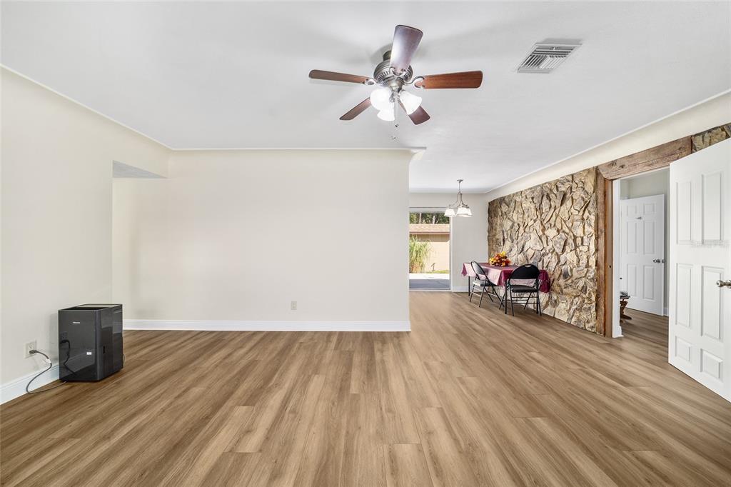 5201 East Jasmine Lane Inverness, FL 34453 - Photo 21 of 50 a view of a livingroom with wooden floor and a ceiling fan