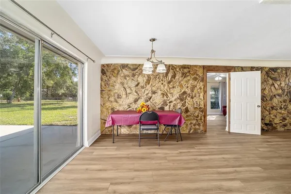 a kitchen with stainless steel appliances granite countertop a refrigerator a oven a sink and white cabinets with wooden floor