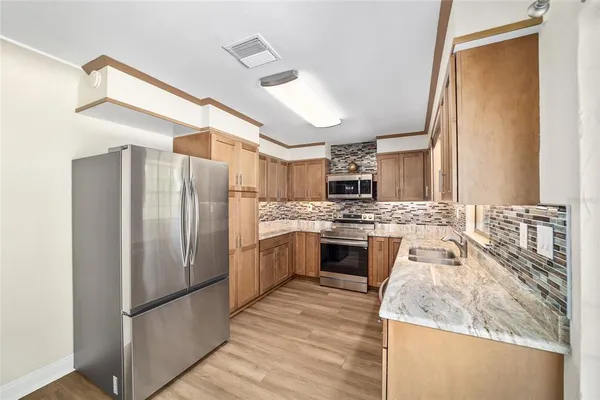 a kitchen with stainless steel appliances granite countertop a sink stove and refrigerator
