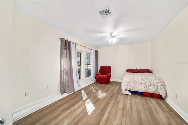 a view of a bedroom with a large bed and a chandelier fan
